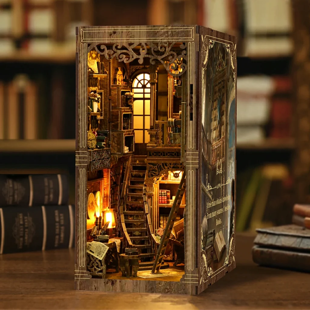 Vista cercana en ángulo del book nook Ancient Book Collection Room terminado, con interior iluminado, escalera de madera, ventana arqueada, estanterías antiguas y detalles de biblioteca vintage.