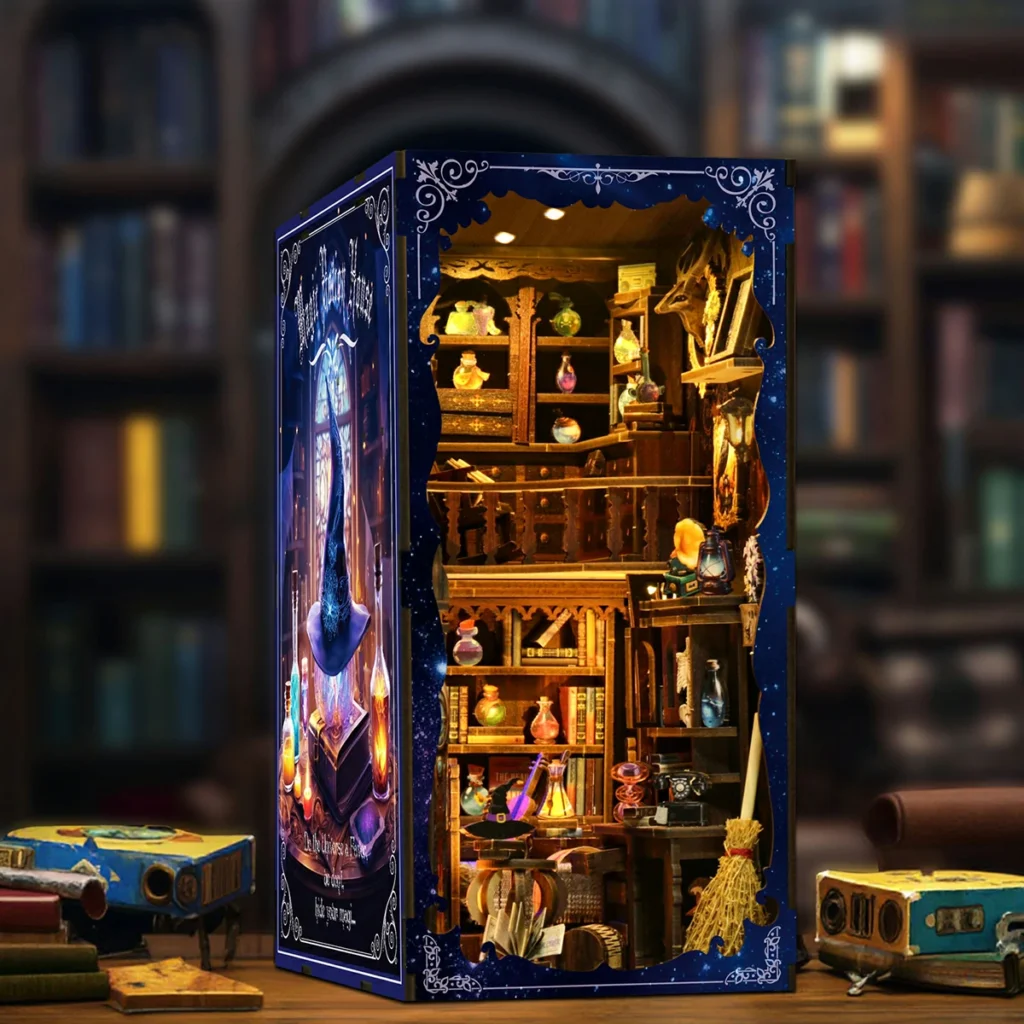 Vista en ángulo del book nook Harry Potter Magical Bookshop terminado sobre una mesa, con interior iluminado, estanterías de pociones, escoba mágica, libros antiguos y portada azul decorativa.